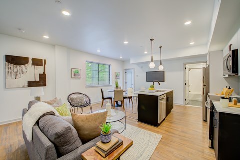 A modern living room with a grey couch and a wooden coffee table.