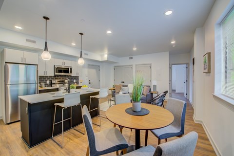 A modern kitchen with a dining table and chairs.