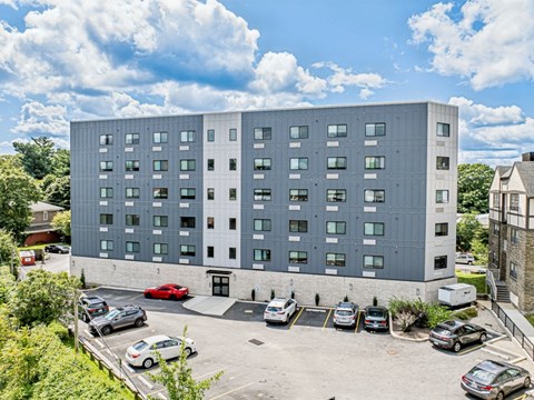 a large gray building with cars parked in a parking lot