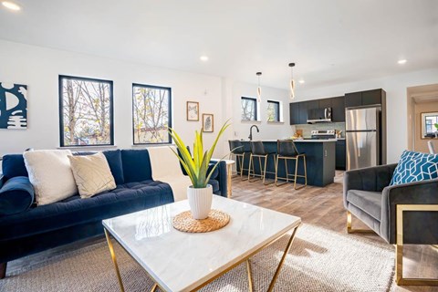 A modern living room with a blue sofa and a white coffee table.