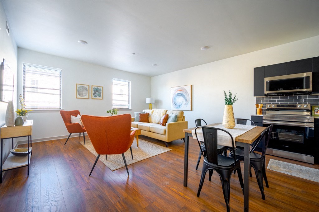 A living room with a wooden floor and furniture.