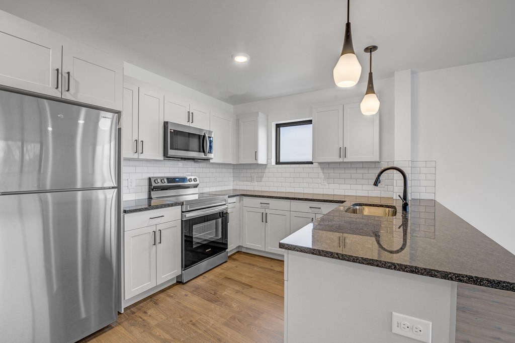 a kitchen with white cabinets and stainless steel appliances