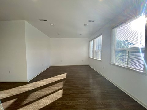 a living room with white walls and a large window