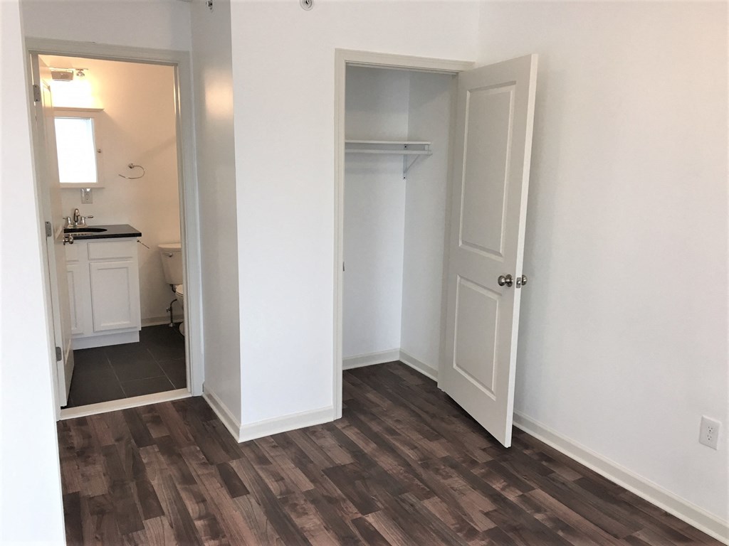 a small room with a door to a bathroom and a closet