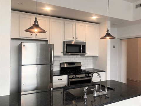 a kitchen with stainless steel appliances and white cabinets