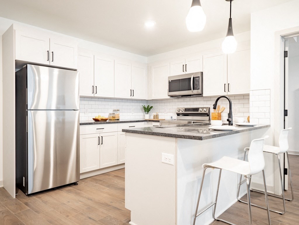 a modern kitchen with stainless steel appliances and white cabinets