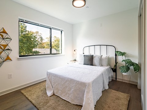 a bedroom with a bed and a large window