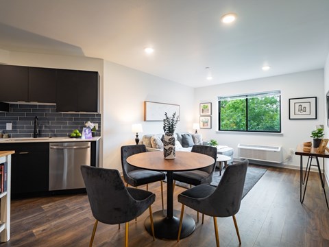 A modern dining room with a round table and chairs.