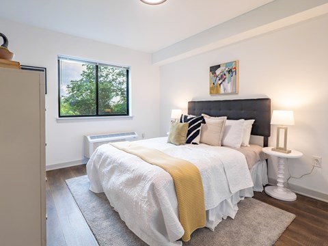 A bedroom with a large bed and a window.