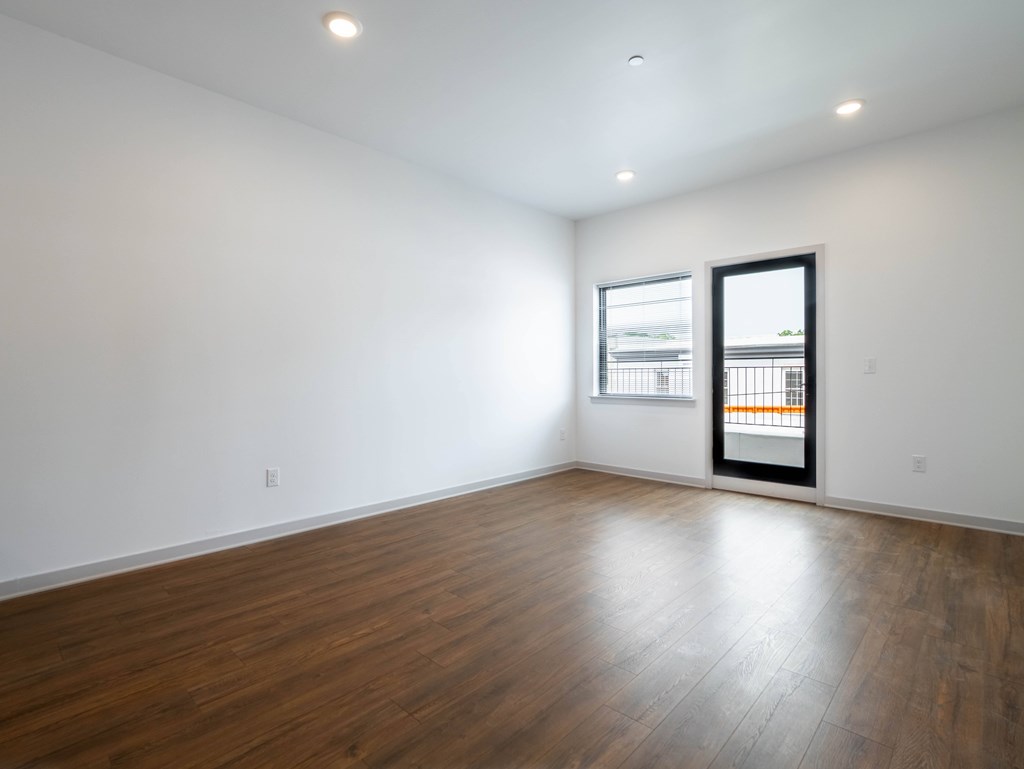 A room with a wooden floor and a window.