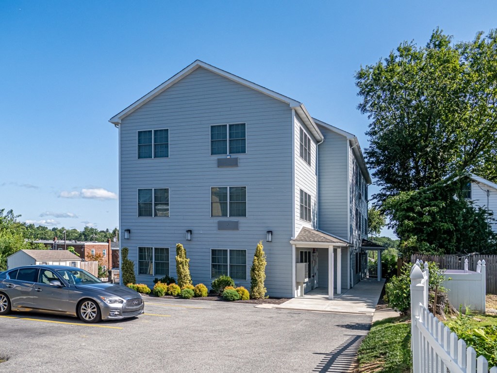 a white building with a car parked in front of it