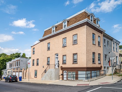 A large brick building with a brown roof and a garage door on the ground floor.