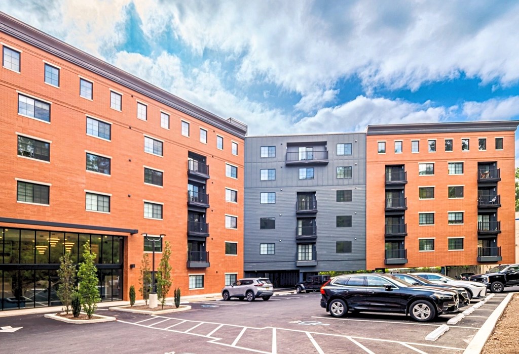 A parking lot with cars and apartment buildings.