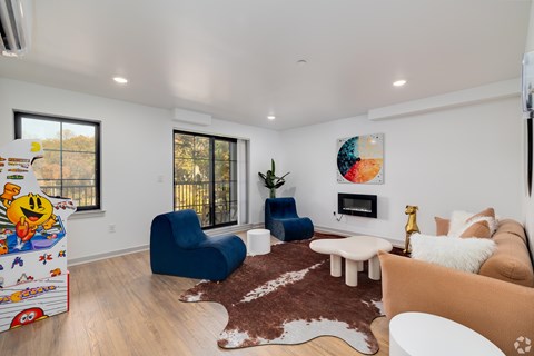 A living room with a blue chair and a cowhide rug.