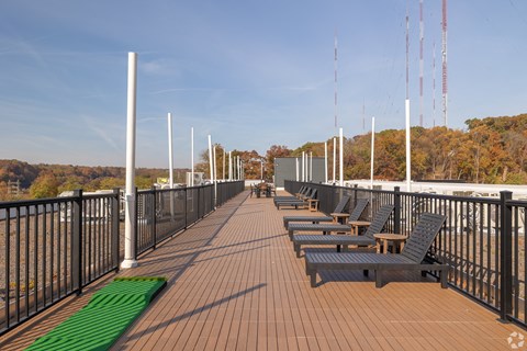 A long wooden deck with benches and a green mat on the ground.