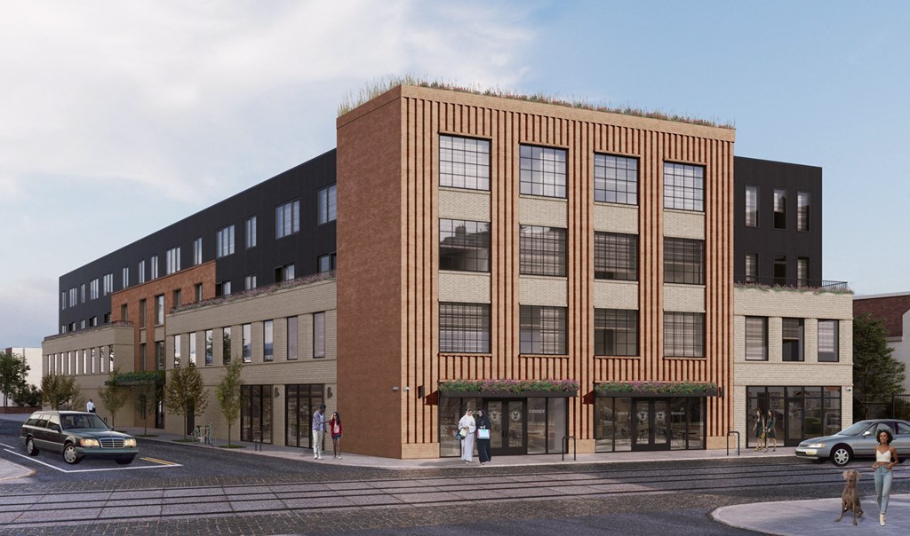 A modern building with a green roof and a car parked in front.
