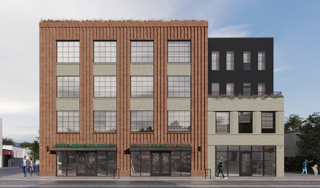 A modern building with a green roof and a brick facade.
