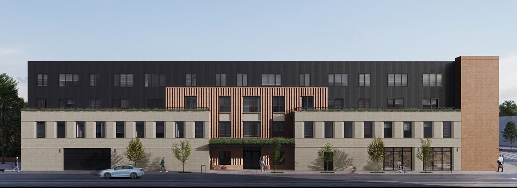 A large black building with a brown section in the middle and a small tree in front of it.