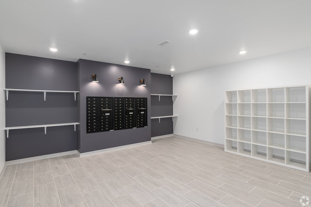 A room with grey walls and white shelves.