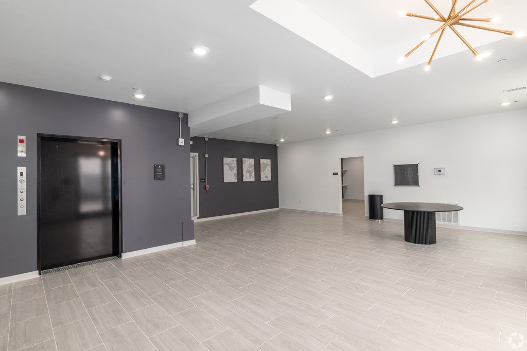 A spacious room with a black door, a table, and a star-shaped light fixture.