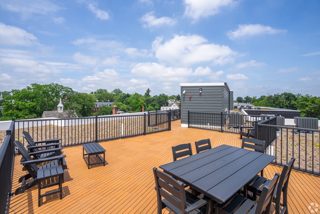 A wooden deck with a table and chairs overlooking a cityscape.