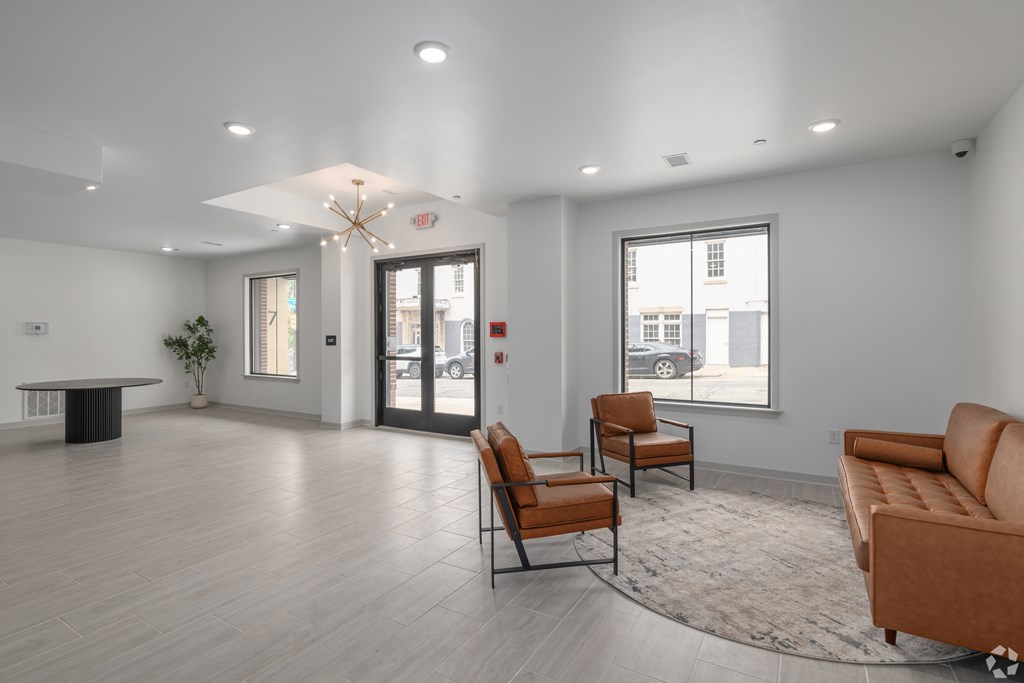 A spacious waiting room with a table, chairs, and a large window.