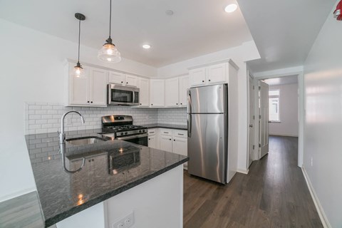a kitchen with white cabinets and a stainless steel refrigerator