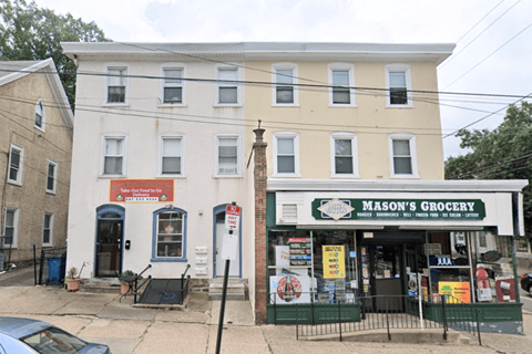 the front of a white building with a grocery store