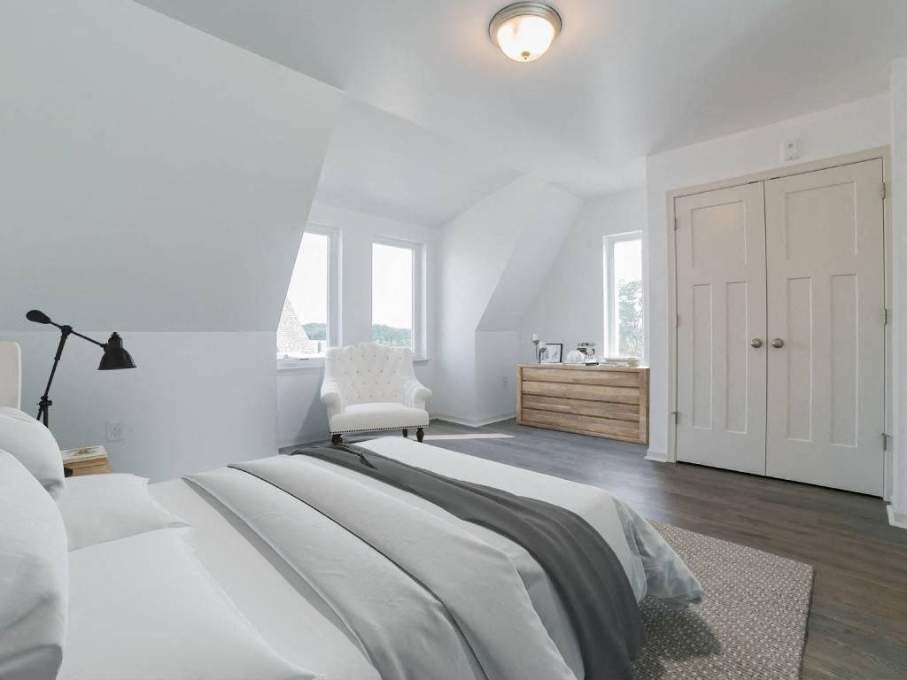 a white bedroom with a bed and a white door