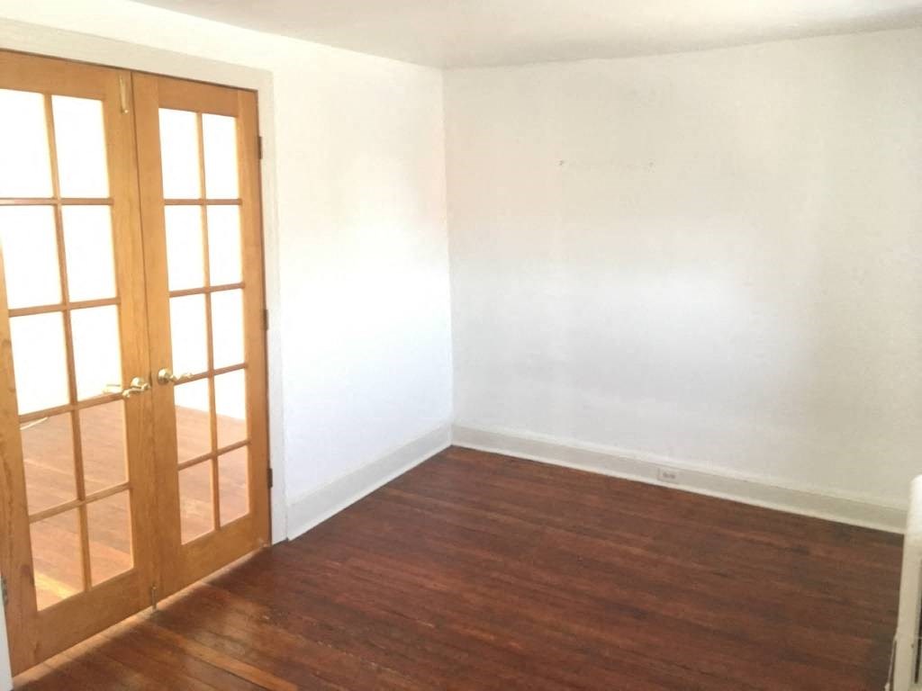 an empty room with white walls and a wooden floor
