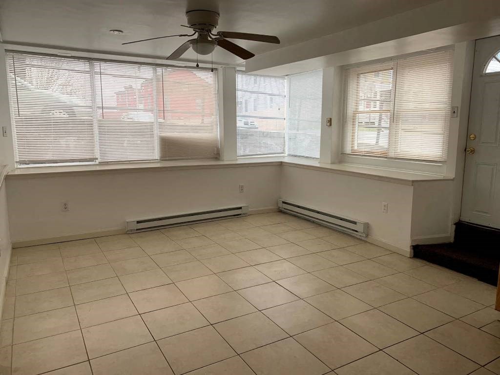 an empty room with a ceiling fan and windows