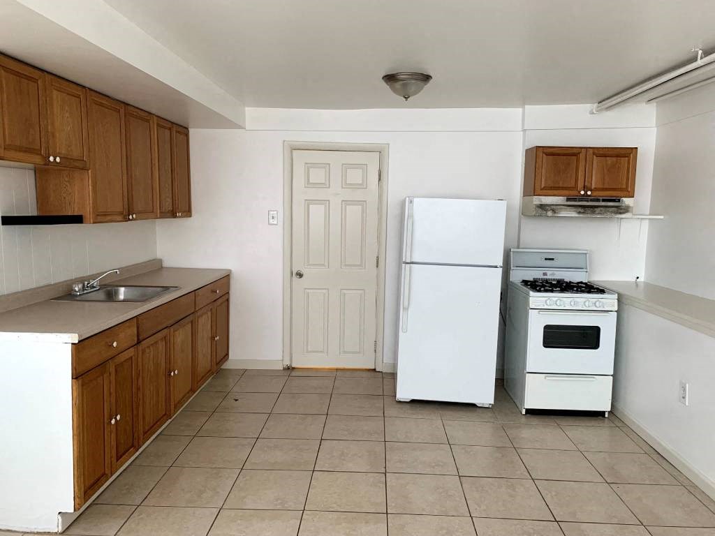 a kitchen with a stove refrigerator and a sink
