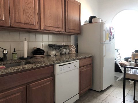 a kitchen with white appliances and wooden cabinets