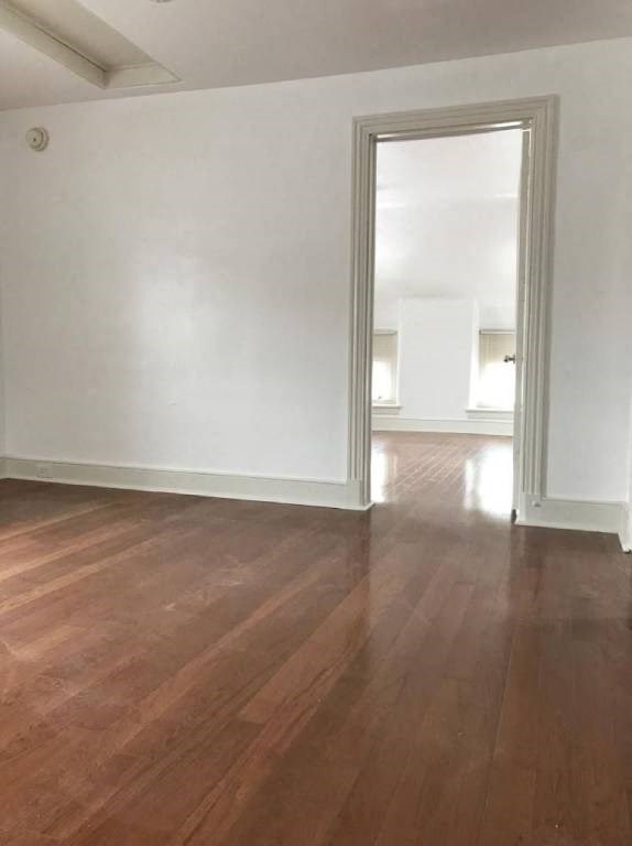 an empty living room with wood floors and a doorway