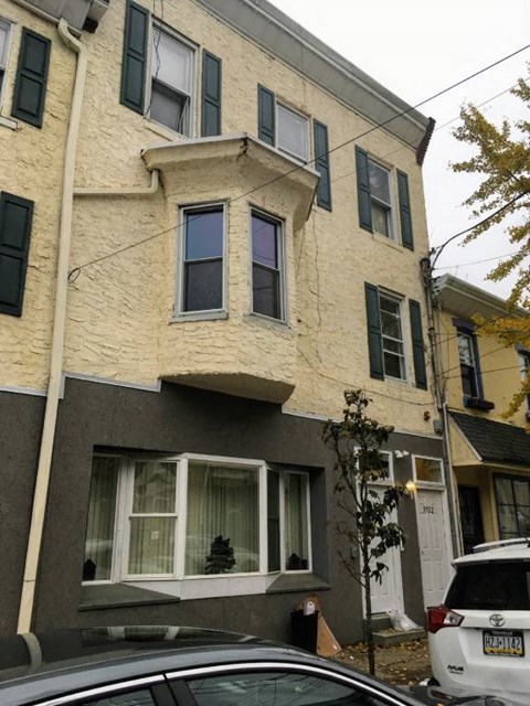 a white building with windows and a car parked in front