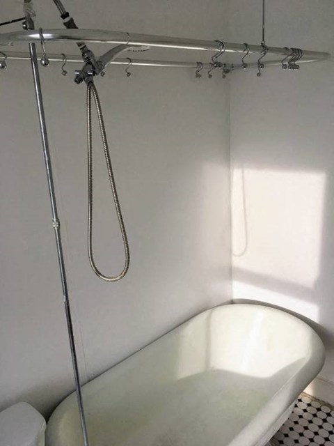a white bathroom with a shower and a bath tub