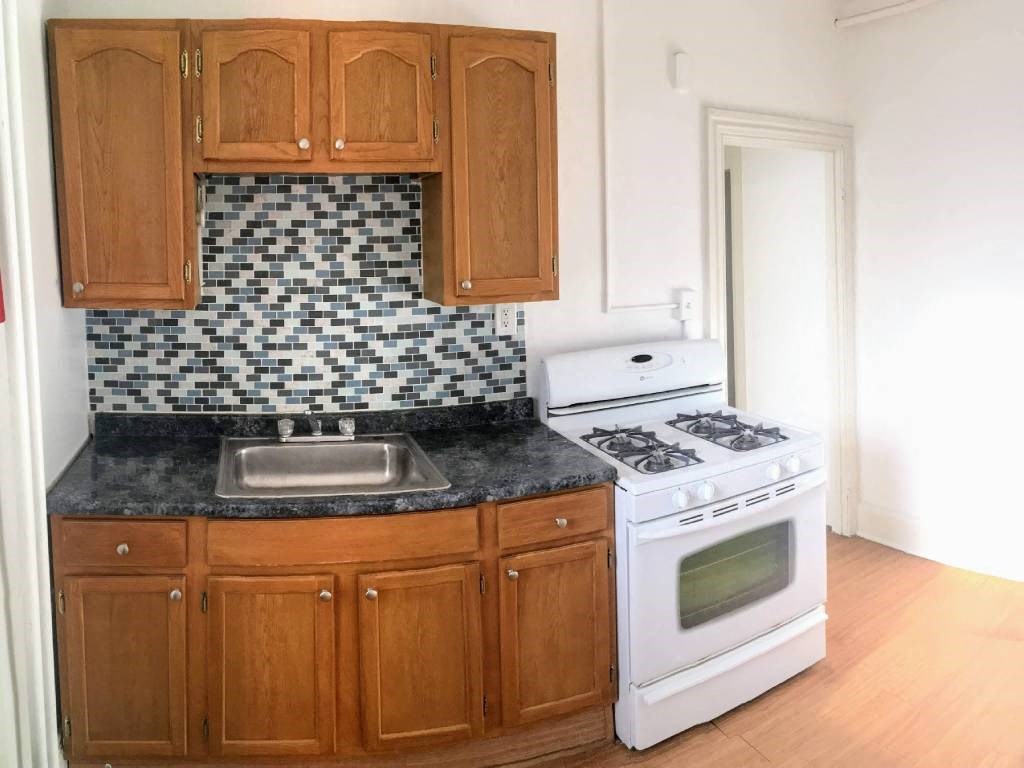 a kitchen with a stove top oven and a sink