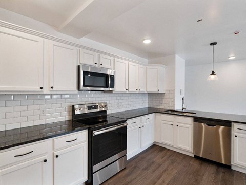 a kitchen with white cabinets and a stove and a microwave