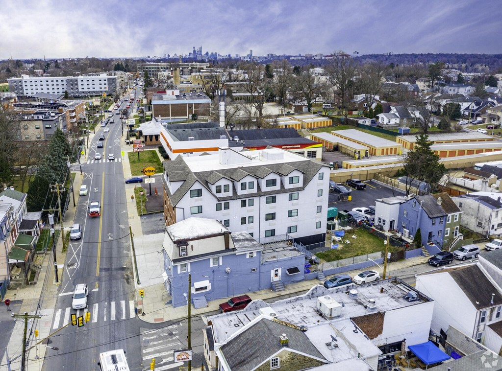 an aerial view of a city with a white house and blue buildings