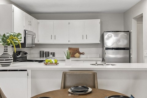 A modern kitchen with a table set for two.