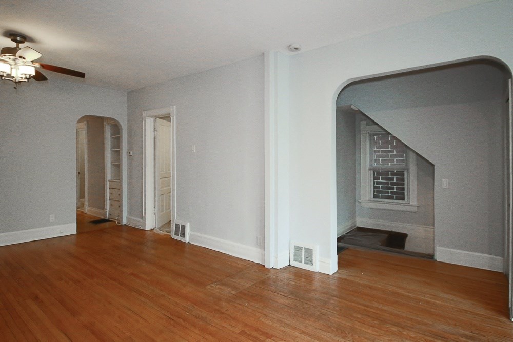 an empty living room with a hard wood floor and a fireplace