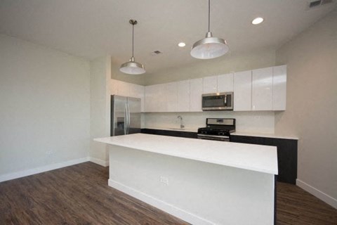 an empty kitchen with a white counter top