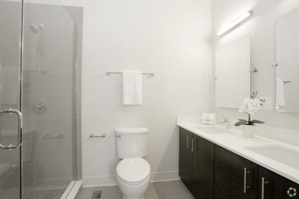 a white bathroom with a toilet and a shower