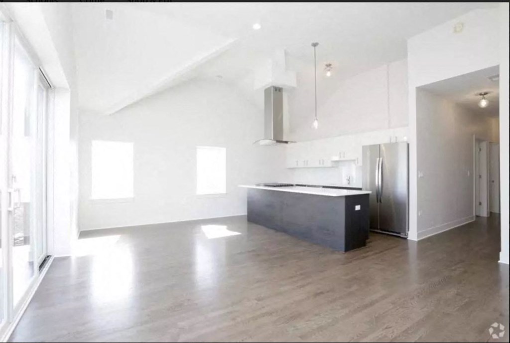 an empty kitchen with white walls and a black island