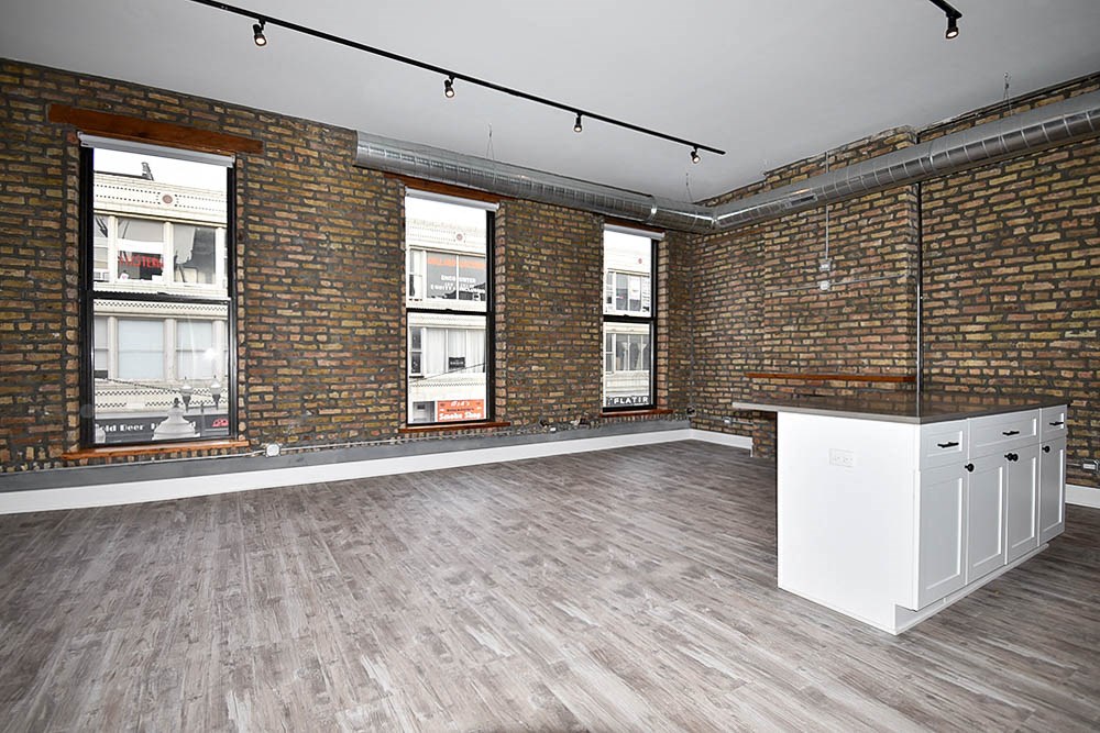 an empty room with brick walls and a white island in the corner