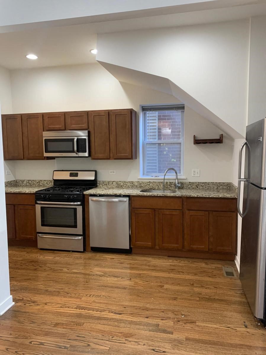 a kitchen with wooden cabinets and stainless steel appliances