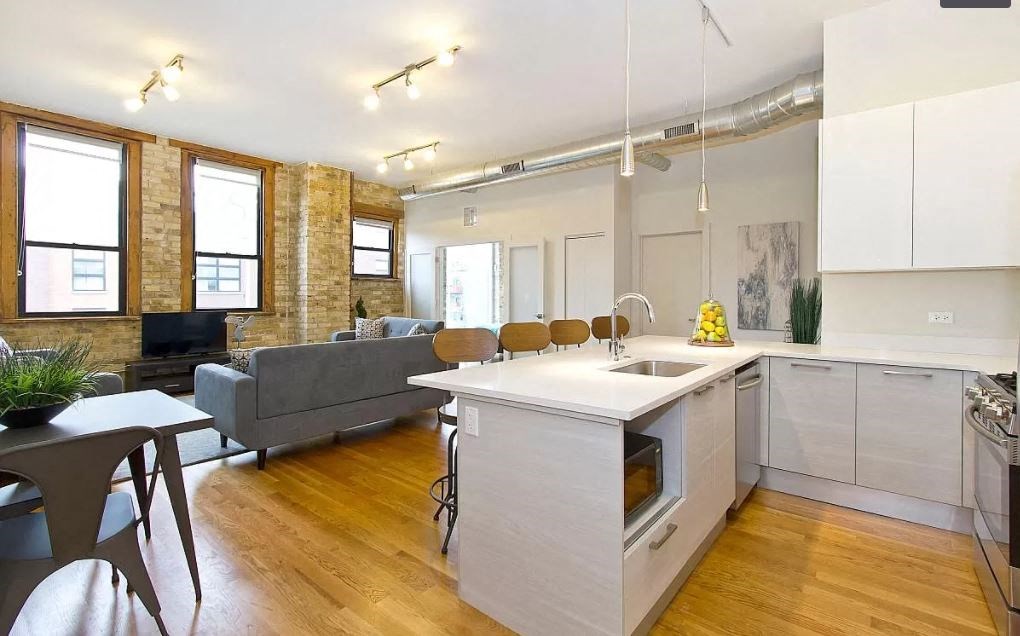 a kitchen and living room with a table and a sink