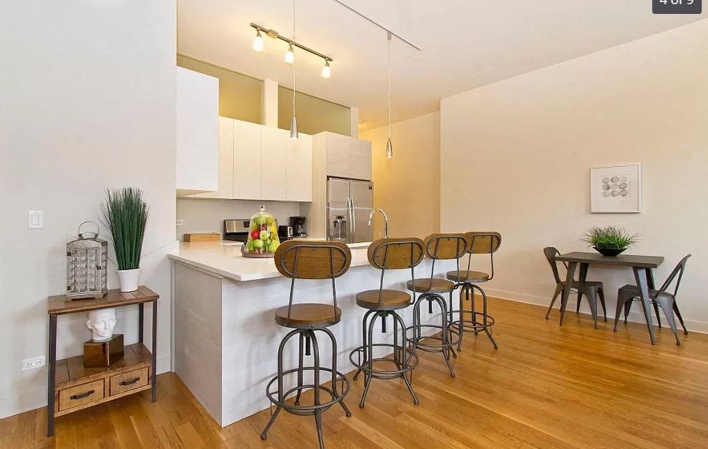a kitchen with a bar and a table with chairs
