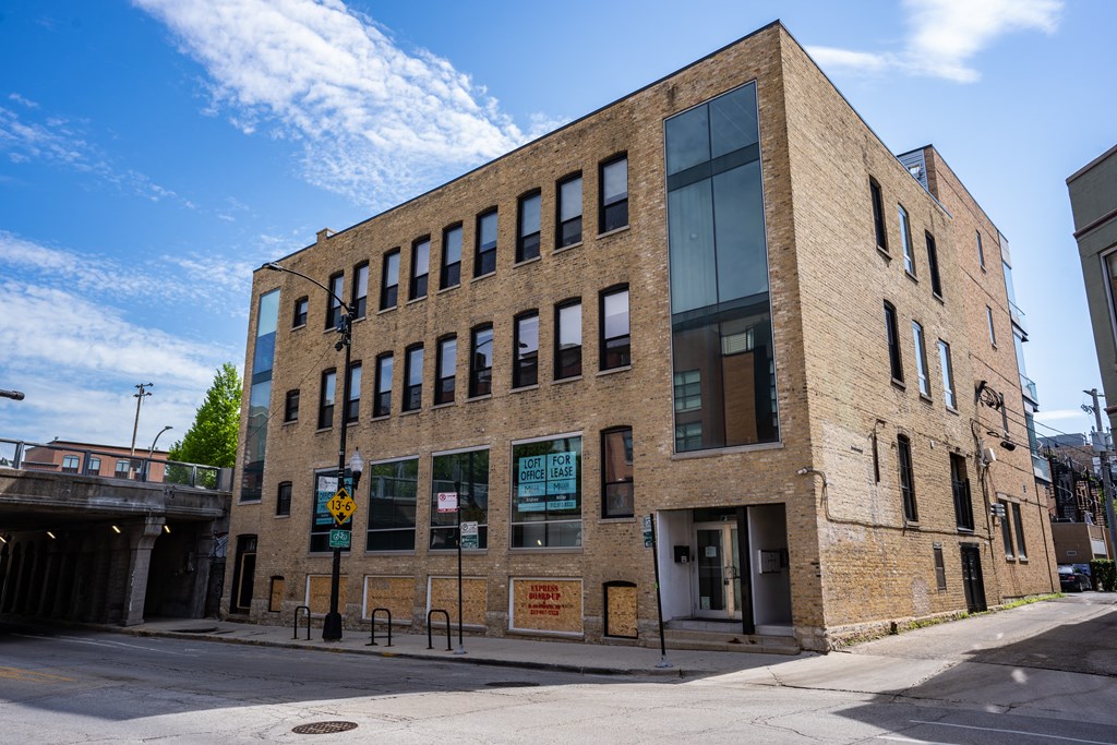 a brick building on a city street with a bridge