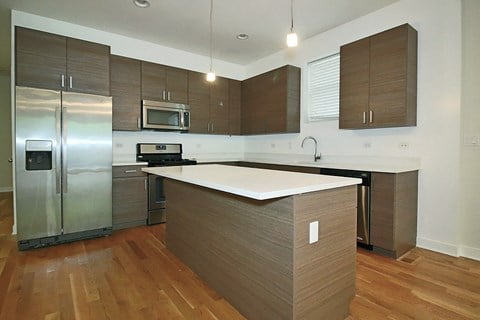 a modern kitchen with stainless steel appliances and a white counter top